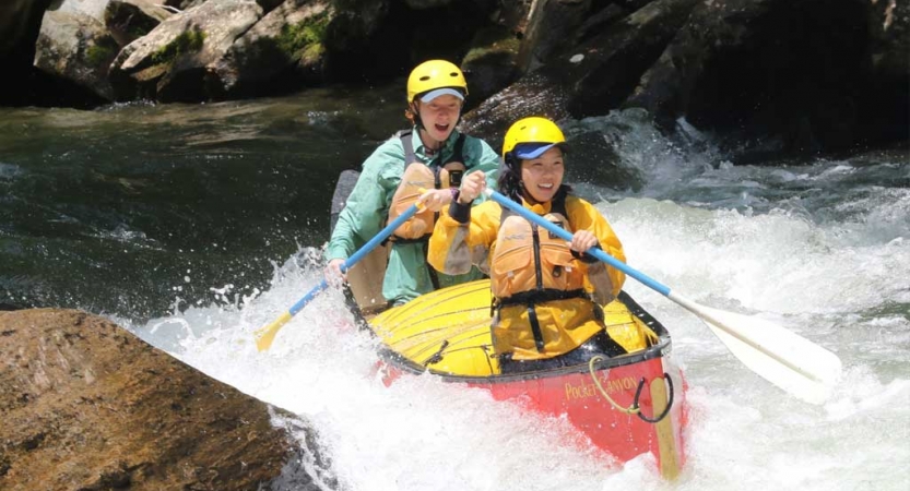 two gap year students paddle a canoe through whitewater on an outward bound expedition in north carolina 